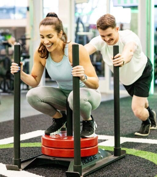 gym members push weight sleds on the functional training area at emerald city athletics in everett